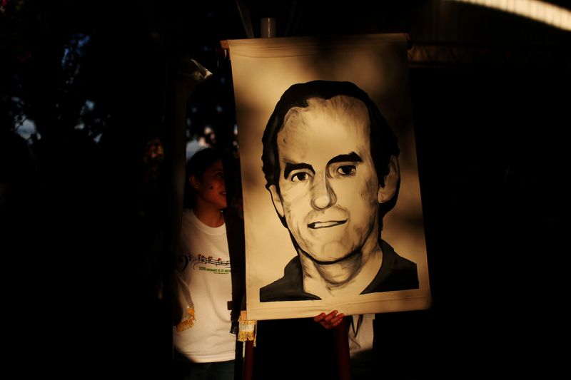 &copy; Reuters. FOTO DE ARCHIVO: Unos estudiantes sostienen un retrato del sacerdote jesuita Ignacio Ellacuria antes de una procesión que conmemora el 28º aniversario del asesinato de varios sacerdotes jesuitas y dos empleados, por las fuerzas militares del gobierno du