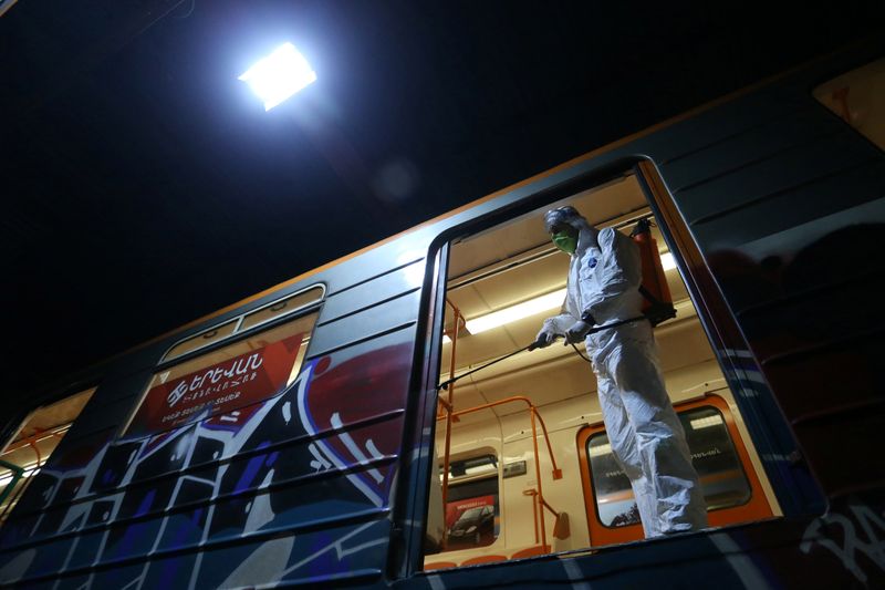 &copy; Reuters. An employee in protective gear sprays disinfectant on a subway train, as part of measures to prevent the spread of coronavirus (COVID-19) in Yerevan