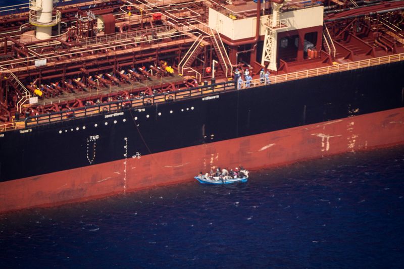 &copy; Reuters. Migrants sit in a boat alongside the Maersk Etienne tanker off the coast of Malta