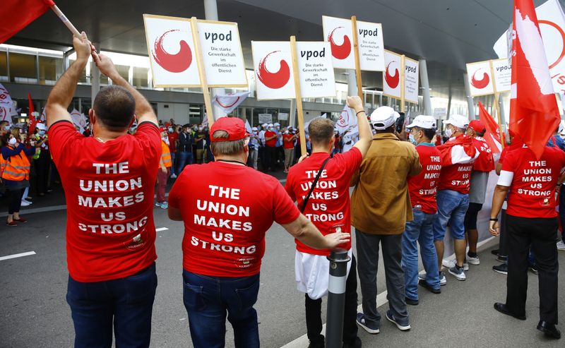 &copy; Reuters. Members of the VPOD public services workers union display placards during a demonstration in front of Zurich Airport
