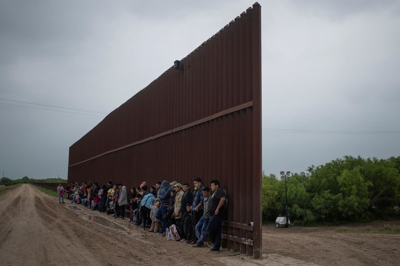 © Reuters. Foto de archivo ilustrativa de un grupo de migrantes centroamericanos junto a una sección del muro fronterizo antes de entregarse a las autoridades de EEUU