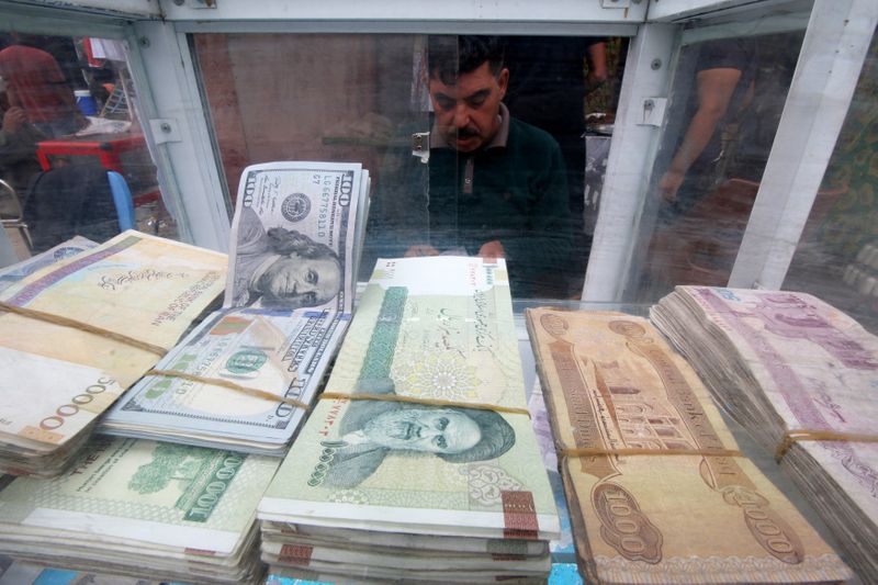 &copy; Reuters. A man counts Iranian rials at a currency exchange shop, before the start of the U.S. sanctions on Tehran, in Basra