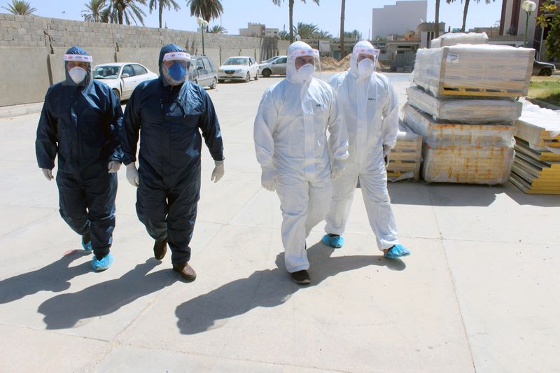 &copy; Reuters. Medical team wearing protective suits walk to a clinic, following the outbreak of the coronavirus disease (COVID-19), in Misrata