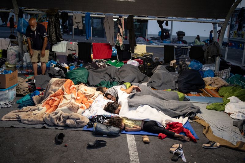 &copy; Reuters. Refugees and migrants from the destroyed Moria camp sleep at the parking space of a supermarket, on the island of Lesbos