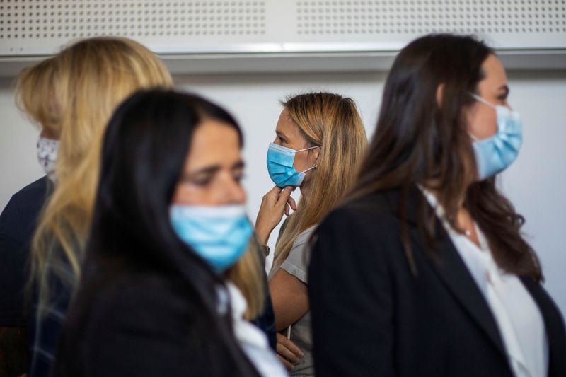 &copy; Reuters. Israeli model Bar Refaeli wears a face mask amid the coronavirus disease (COVID-19) pandemic as she flanked by her lawyers and her mother inside a courtroom in Tel Aviv