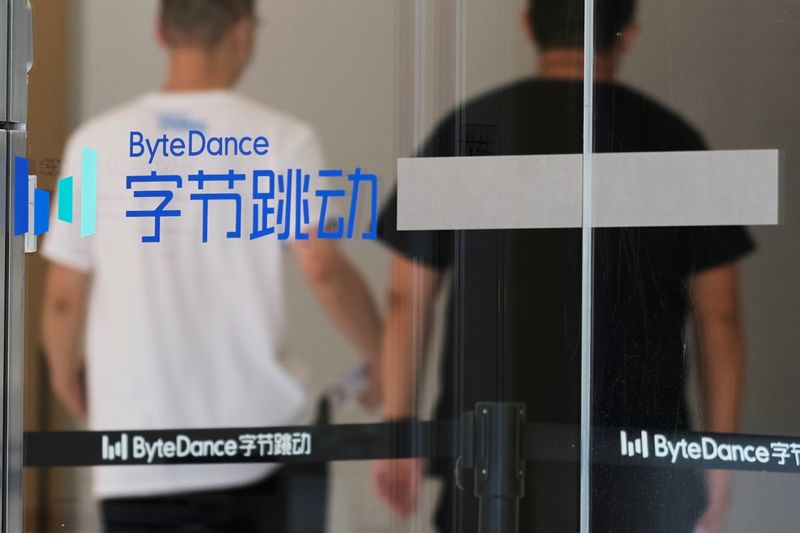 &copy; Reuters. Due passanti vicino al logo di Bytedance presso l&apos;ufficio del gruppo a Pechino, 7 luglio 2020