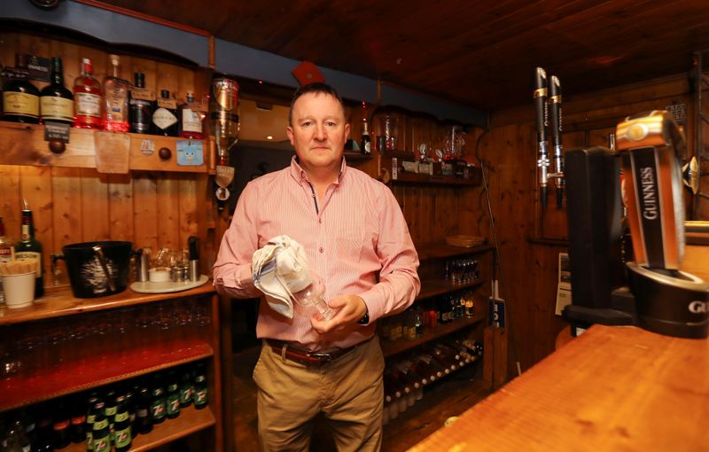 © Reuters. Publican Paul Moynihan prepares for reopening his pub in Donard, County Wicklow, Ireland