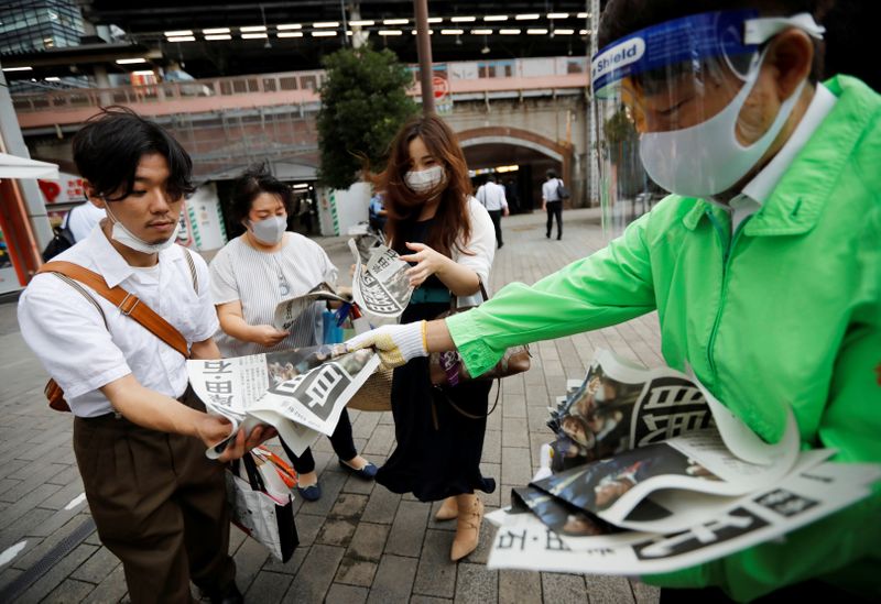 © Reuters. People receive extra editions of a newspaper reporting Japanese Chief Cabinet Secretary Yoshihide Suga won in a ruling party leadership election paving the way for him to replace Prime Minister Shinzo Abe in Tokyo