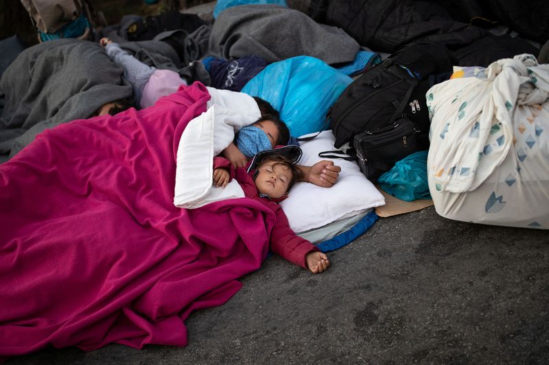 &copy; Reuters. Refugees and migrants sleep on a road following a fire at the Moria camp on the island of Lesbos