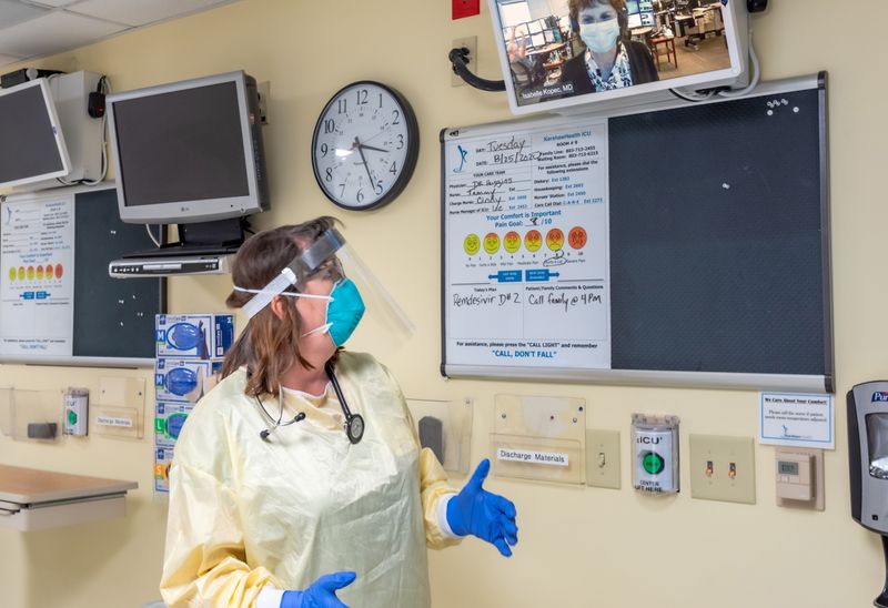 © Reuters. Tallulah Holmstrom, chief medical officer, wears a protective gear in her intensive-care unit and discusses the coronavirus disease (COVID-19) with Isabelle Kopec, in Camden