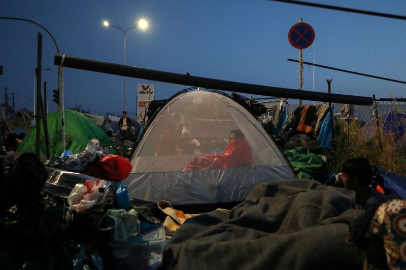 © Reuters. A woman is seen inside a tent as refugees and migrants from the destroyed Moria camp sleep, near a new temporary camp, on the island of Lesbos