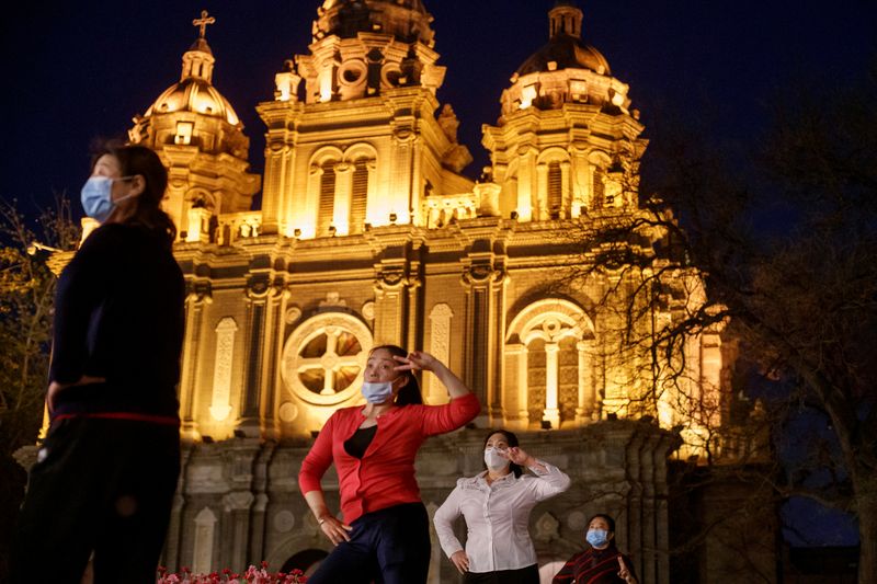 &copy; Reuters. FILE PHOTO: Women take part in a square dance routine in front of St. Joseph&apos;s Catholic Church in Beijing as the spread of the novel coronavirus disease (COVID-19) continues in Beijing