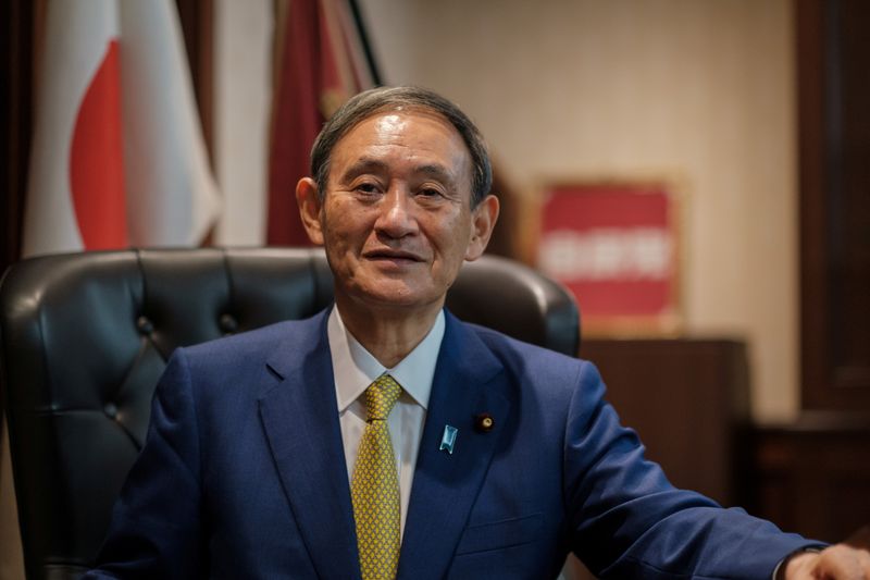 &copy; Reuters. Yoshihide Suga poses for a picture following a press conference in Tokyo