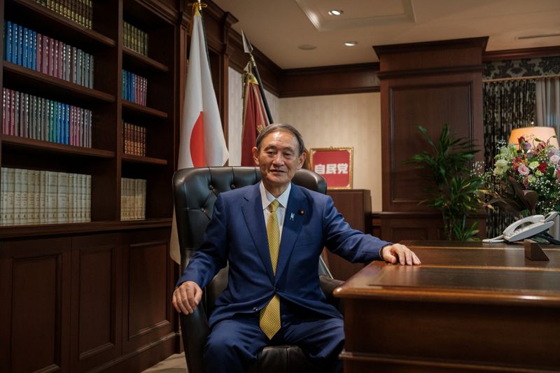 &copy; Reuters. Yoshihide Suga poses for a picture following a press conference in Tokyo