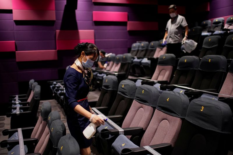 © Reuters. A staff member wearing a face mask disinfects seats in a cinema as it reopens following the coronavirus disease (COVID-19) outbreak, in Shanghai