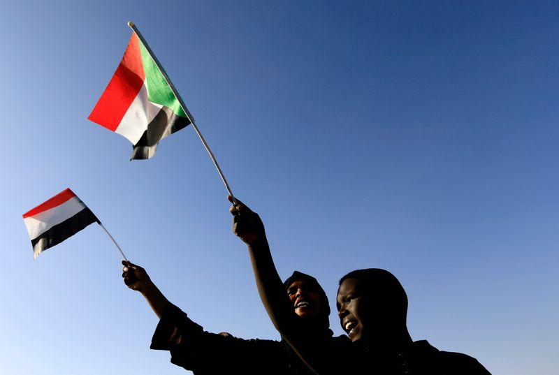&copy; Reuters. FILE PHOTO: Sudanese civilians wave their national flag as they gather at the freedom square during the first anniversary of the start of the uprising that toppled long-time ruler Omar al-Bashir, in Khartoum