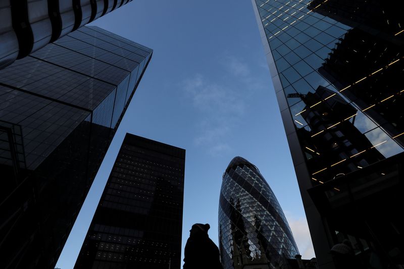 &copy; Reuters. A pedestrian walks past skyscrapers in the financial district in London