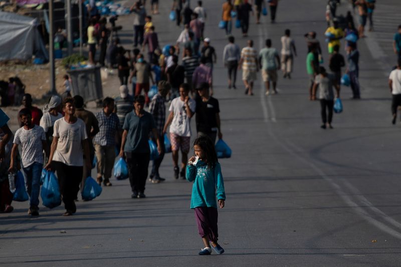 © Reuters. Refugees and migrants from destroyed Moria near new temporary camp, on Lesbos