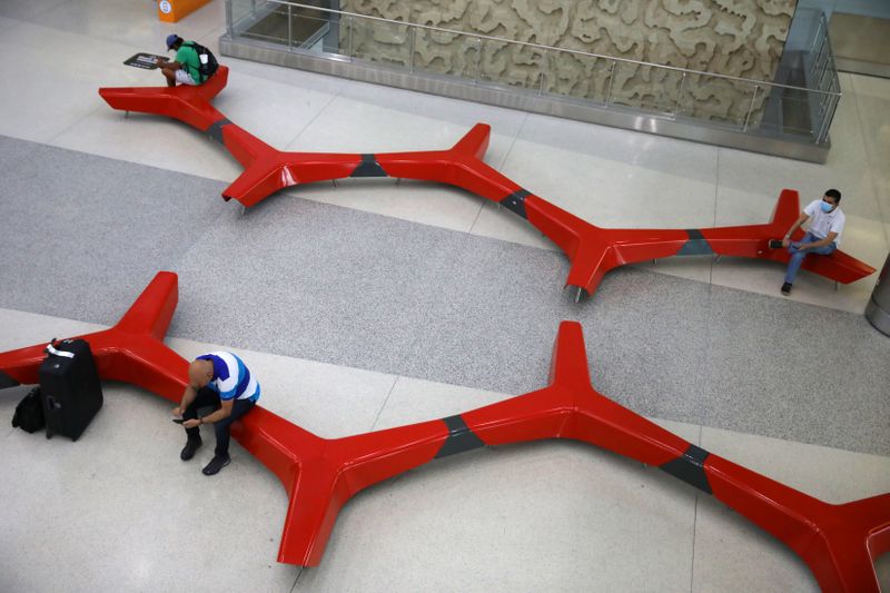 &copy; Reuters. Passengers practice &apos;social distancing&apos; at a main Miami International Airport terminal