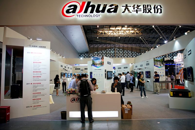 © Reuters. FILE PHOTO: People visit a Dahua Technology booth at a security exhibition in Shangha