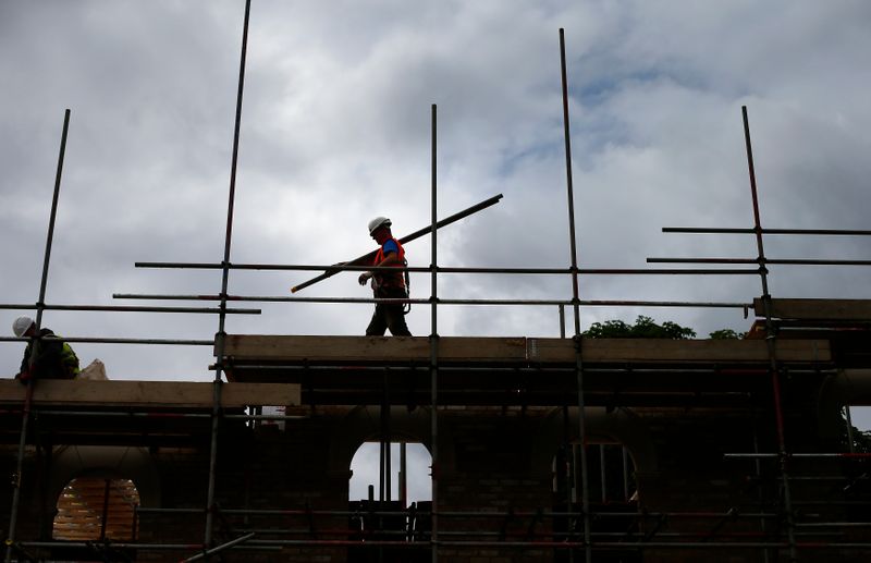 &copy; Reuters. FILE PHOTO: A builder assembles scaffolding as he works on new homes in south London