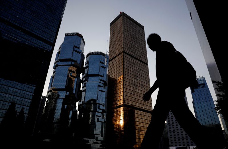 &copy; Reuters. FILE PHOTO: A man walks past buildings at a business district in Hong Kong