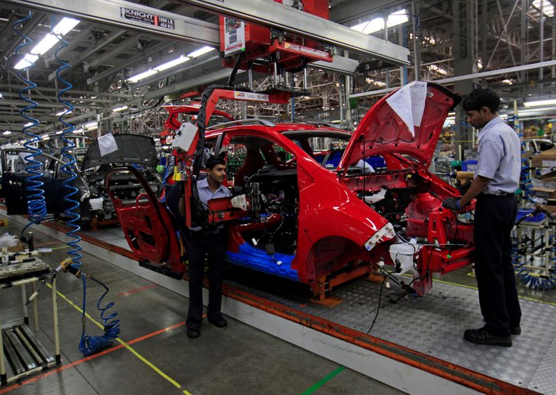 &copy; Reuters. FILE PHOTO: Employees work on a Chevrolet Beat car on an assembly line at the General Motors plant in Talegaon
