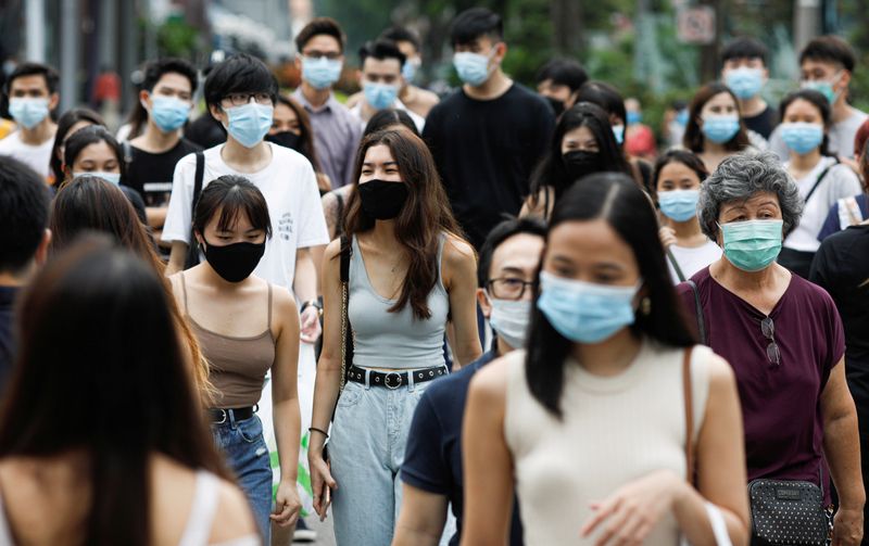 &copy; Reuters. FILE PHOTO: People cross a street at the shopping district of Orchard Road as the city state reopens the economy, amid the coronavirus disease (COVID-19) outbreak, in Singapore