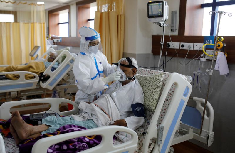 &copy; Reuters. Медицинский работник и пациент, инфицированный COVID-19, в больнице в Ноиде