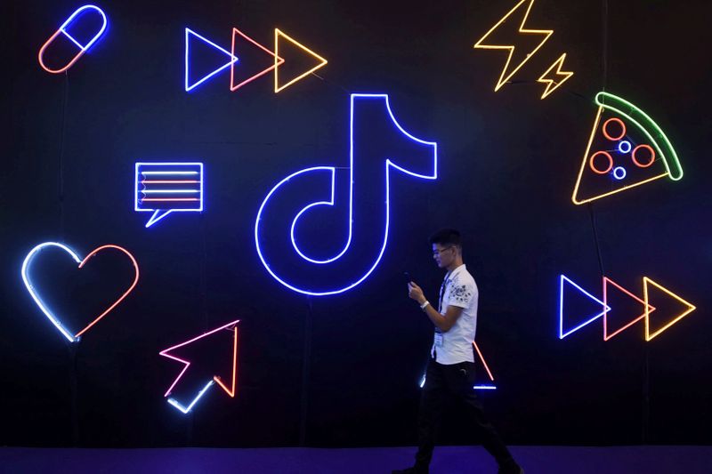 © Reuters. FILE PHOTO: Man walks past a sign of ByteDance's app TikTok, known locally as Douyin, at an expo in Hangzhou