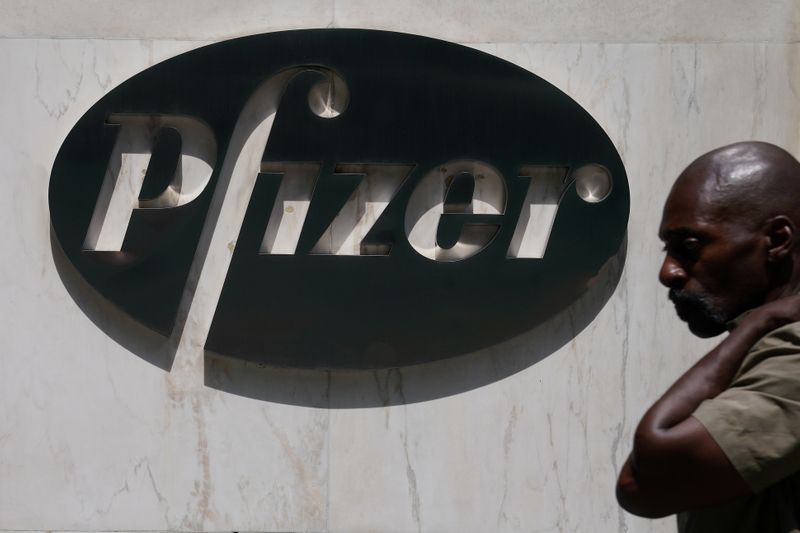 &copy; Reuters. FILE PHOTO: A man walks past a sign outside Pfizer Headquarters in the Manhattan borough of New York City