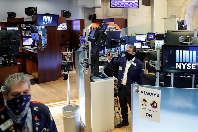 &copy; Reuters. Traders wearing masks watch as the Opening Bell rings, on the first day of in-person trading since the closure during the outbreak of the coronavirus disease (COVID-19) on the floor at the NYSE in New York