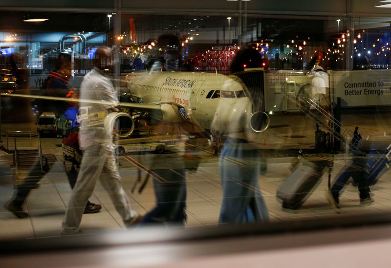 &copy; Reuters. Passengers&apos; reflections are seen in a terminal window with a South African Airways (SAA) plane on the apron at OR Tambo International Airport in Johannesburg