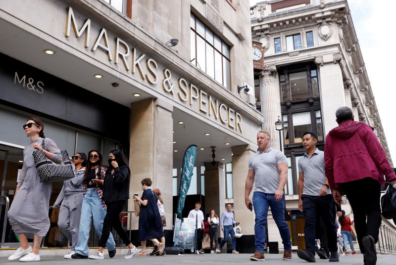 © Reuters. FILE PHOTO: People walk outside the Marks&Spencer shop amid the outbreak of the coronavirus disease (COVID-19), in Oxford Street