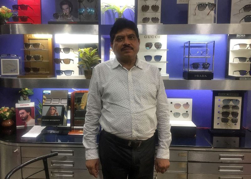 © Reuters. Gajendra Sharma poses inside his shop selling eye glasses in Agra