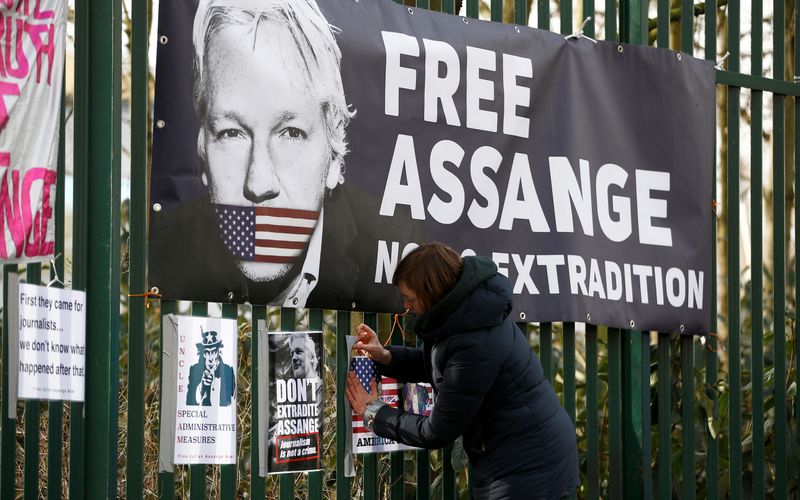 &copy; Reuters. Apoiador de Assange prende cartaz em grade de tribunal em Londres