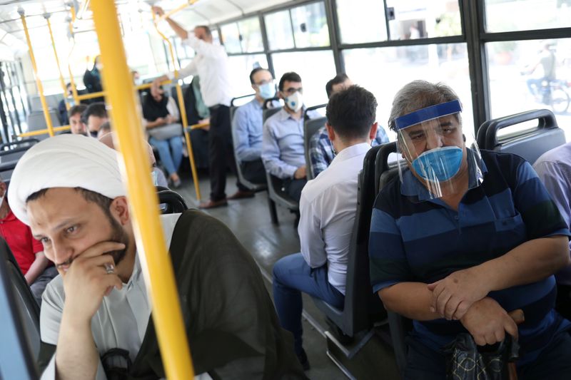 &copy; Reuters. Iranians wearing protective masks and face shields ride a bus, following the outbreak of the coronavirus disease (COVID-19), in Tehran
