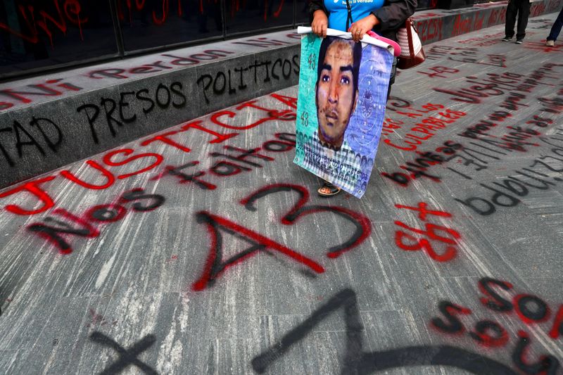 &copy; Reuters. FILE PHOTO:  A relative of a missing student holds a poster with his image during a protest outside the Attorney General&apos;s office, in Mexico City