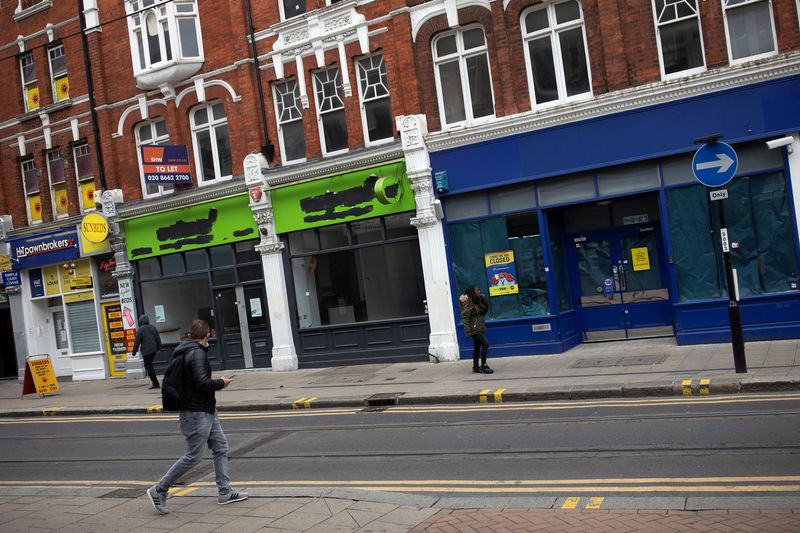 &copy; Reuters. Pedestrians walk past closed retail stores in Croydon, south London