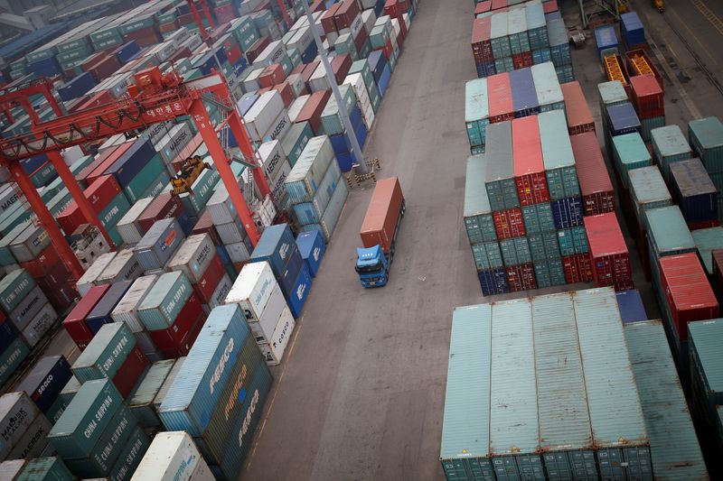 &copy; Reuters. FILE PHOTO: A truck drives between shipping containers at a container terminal at Incheon port in Incheon