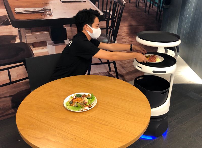 © Reuters. SoftBank's robotics arm demonstrates a food service robot Servi, developed for restaurants grapple with labour shortages and seek to ensure social distancing during the coronavirus disease (COVID-19) outbreak, in T