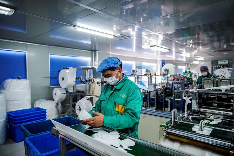 &copy; Reuters. FILE PHOTO: Workers are seen on a production line manufacturing masks at a factory in Shanghai,