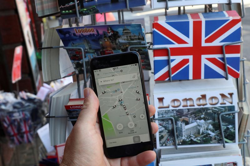 © Reuters. FILE PHOTO: A photo illustration shows the Uber app and London themed postcards in London