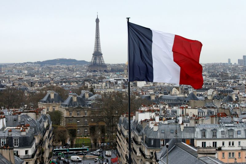 &copy; Reuters. FILE PHOTO: A French flag waves above the skyline as the Eiffel Tower and roof tops are seen in Paris, France