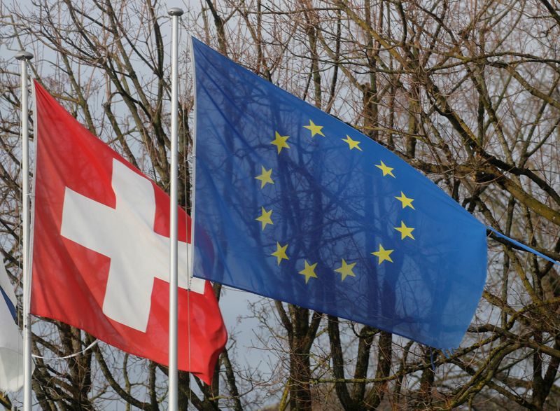 © Reuters. FILE PHOTO: Switzerland's national flag flies beside the one of the European Union in Steinhausen