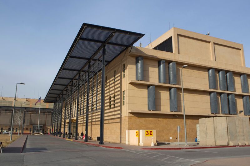 © Reuters. Pedestrians walk past an annex building inside the compound of the U.S. embassy in Baghdad