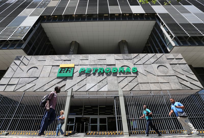 &copy; Reuters. People walk in front of the headquarters of Petroleo Brasileiro S.A. (Petrobas) in Rio de Janeiro