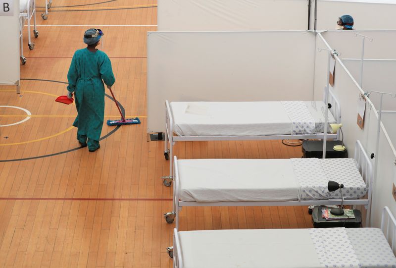 © Reuters. A health worker walks between beds at a temporary field hospital set up by Medecins Sans Frontieres (MSF) during the coronavirus disease (COVID-19) outbreak in Khayelitsha township near Cape Town