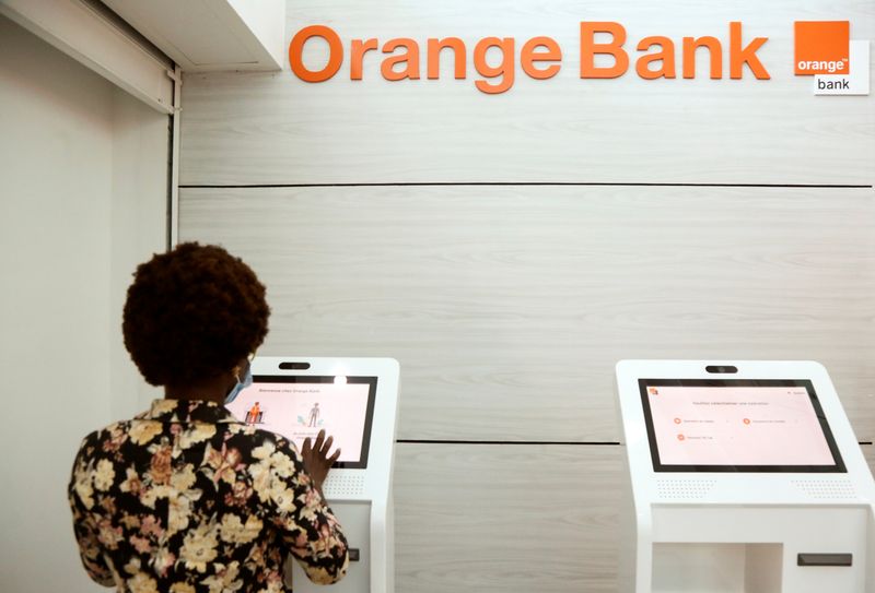 &copy; Reuters. A woman performs a financial transaction at a bank of the French mobile operator Orange in Abidjan, Ivory Coast