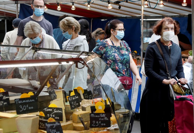 &copy; Reuters. FILE PHOTO: People wear protective masks at an open-air market, in Paris